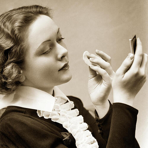 1930s-woman-powdering-her-nose-looking-into-compact-mirror-holding-powder-puff-wearing-top-panoramic-images