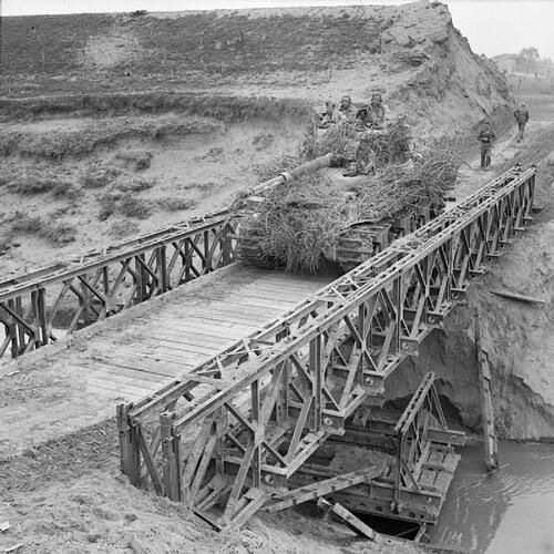 A-heavily-camouflaged-Sherman-tank-crosses-a-Bailey-bridge-over-the-River-Santerno-near-Imola-12-April-1945_
