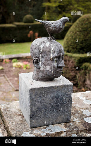 sculpture-of-head-with-a-bird-perching-and-bird-droppings-wyndcliffe-court-sculpture-gardens-monmouthshire-MBF55J