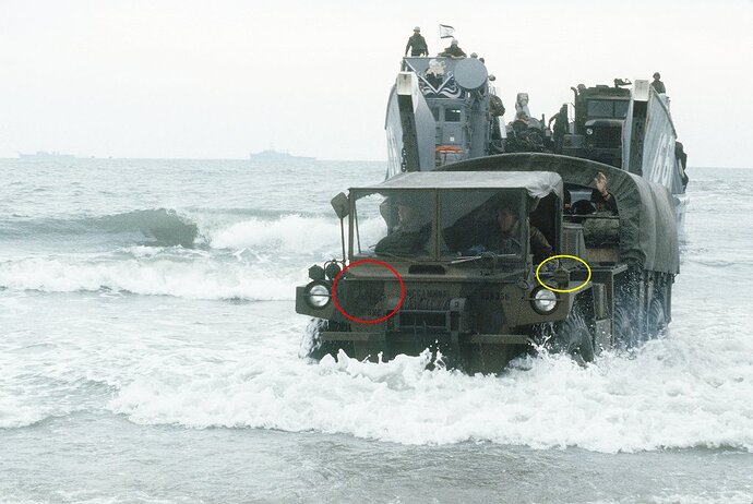 an-m561-1-14-ton-truck-towing-a-trailer-comes-ashore-from-a-utility-landing - badge ID