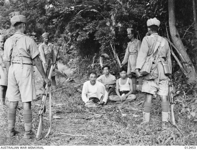 MALAYA. INDIAN TROOPS GUARDING NATIVE SUSPECTS